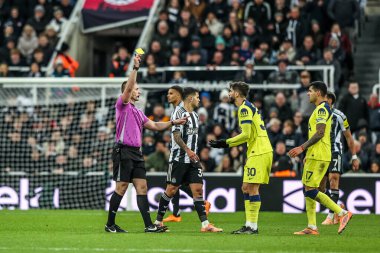 Referee Thomas Bramall gives a yellow card to Rodrigo Bentancur of Tottenham Hotspur during the Premier League match Newcastle United vs Tottenham Hotspur at St. James's Park, Newcastle, United Kingdom, 2nd December 2025 
