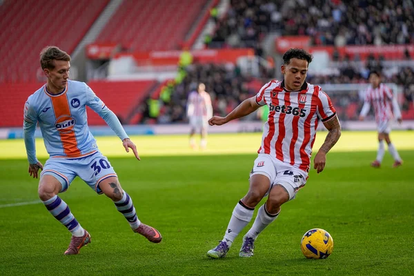 Stoke City 'den Ben Pearson, Stoke City - Stoke City - Swansea City maçında Swansea City maçında Swansea City' den Ethan Galbraith tarafından 13 Aralık 2025 'te Stoke-on-Trent, İngiltere' de top sürüyor.