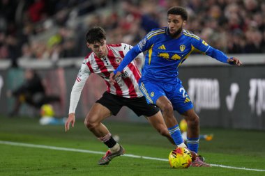 Leeds United takımından Jayden Bogle, Premier Lig karşılaşmasında Brentford 'lu Aaron Hickey' nin baskısıyla Londra, İngiltere 'deki Gtech Community Stadyumu' nda Brentford-Leeds United maçında topu aldı.