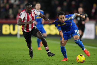 Brentford 'dan Michael Kayode, Premier League karşılaşmasında Leeds United' tan Noah Okafor 'u Londra' daki Gtech Community Stadyumu 'nda 14 Aralık 2025' te Brentford-Leeds United maçında durdurmaya çalışıyor.