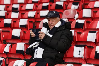 Bir Tottenham taraftarı, İngiltere 'nin Nottingham şehrinde 14 Aralık 2025' te oynanan Premier Lig maçında Nottingham Forest 'a karşı Tottenham Hotspur maçında eşarbını takarak koltuğuna oturuyor.