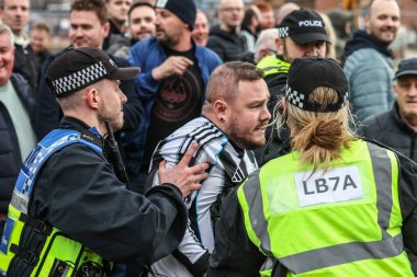 Bir Newcastle taraftarı Sunderland taraftarlarıyla karşı karşıya gelir ve Premier League maçı sırasında Sunderland - Newcastle United Stadyumu, Sunderland, İngiltere, 14 Aralık 2025 'te oynanan karşılaşmada polis tarafından itilir.