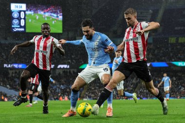 Rayan Cherki of Manchester City is tackled by Kristoffer Ajer of Brentford during the Carabao Cup Quarter Final match Manchester City vs Brentford at Etihad Stadium, Manchester, United Kingdom, 17th December 2025