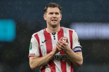 Brentford 'dan Nathan Collins, 17 Aralık 2025 tarihinde Etihad Stadyumu' nda oynanan Carabao Kupası çeyrek final maçında taraftarları alkışlıyor.