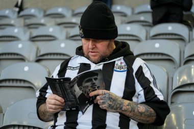 Bir Newcastle taraftarı programı 20 Aralık 2025 'te St. James' s Park, Newcastle, İngiltere 'de oynanan Premier League maçı sırasında okudu.