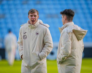 Swansea City 'den Kaelan Casey ve Swansea City' den Bobby Wales, Coventry City, Coventry Building Society Arena 'da 26 Aralık 2025' te oynanan Sky Bet Şampiyonası maçında sahaya bakıyor.