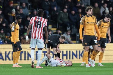 Hakem Craig Pawson, Stoke City 'nin 1 Ocak 2026' da MKM Stadyumu 'nda oynanan Sky Bet Şampiyonası maçında yaralanan Stoke City' li Robert Bozenik 'i kontrol ediyor.