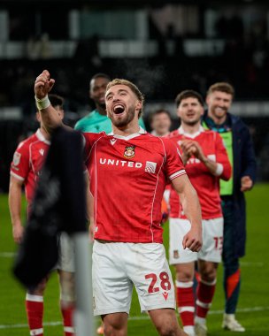 Wrexham 'dan Sam Smith önderliğindeki Wrexham, Derby karşısında 1-2' lik galibiyetini kutluyor ve 4 Ocak 2026 'da İngiltere' nin Derby Stadyumu 'nda oynanan Sky Bet Şampiyonası' nda oynanan son ıslık çalması sonrasında taraftarları alkışlıyor.