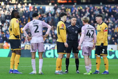 Hakem adı, Stephen Martin, 10 Ocak 2026 'da İngiltere' nin Wolverhampton kentinde oynanan Emirates FA Cup Üçüncü Raundunda Wolverhampton Wanderers - Shrewsbury Town maçında kutudaki tartışmanın ardından her iki tarafla da sohbet ediyor.