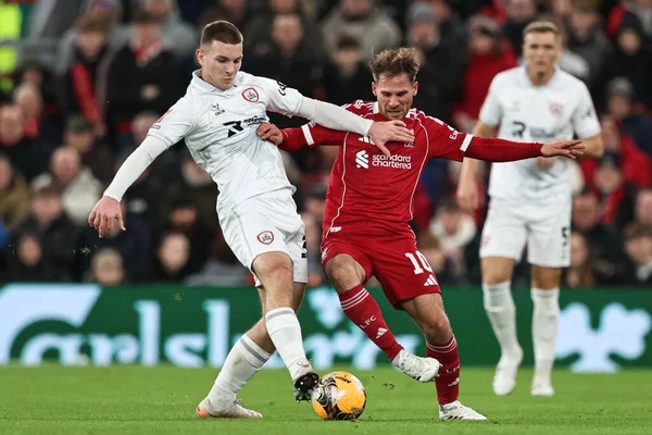 Barnsley 'den Jonathan Bland, Liverpool' lu Alexis Mac Allister 'dan, 12 Ocak 2026 tarihinde Liverpool, Liverpool, İngiltere' de Liverpool 'a karşı oynanan Liverpool FA Cup üçüncü tur karşılaşmasında topu alıyor.