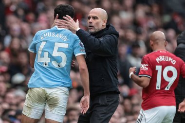 Manchester City 'nin Pep Guardiola teknik direktörü Manchester United' ın Manchester City 'e karşı 17 Ocak 2026' da Old Trafford, Manchester City 'de oynadığı Premier League maçında topu kazandıktan sonra Manchester City' den Abdukodir Khusanov 'u kucaklıyor.