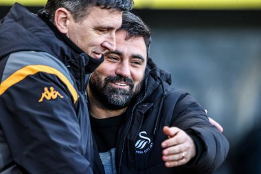 Hull City 'nin Sergej Jakirovi teknik direktörü, 24 Ocak 2026' da İngiltere 'nin Hull şehrindeki MKM Stadyumu' nda oynanan Sky Bet Şampiyonası maçında Swansea City 'nin Vitor Matos teknik direktörünü kucaklıyor.