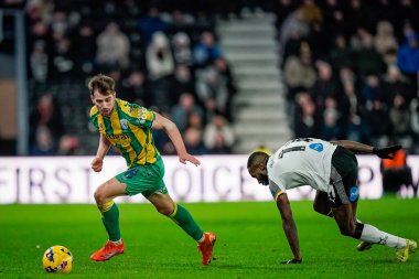 West Bromwich Albion takımından Jayson Molumby, Derby County - West Bromwich Albion maçında 23 Ocak 2026 'da İngiltere' nin Pride Park Stadyumu 'nda oynanan maçta Derby County' den Corey Blackett-Taylor 'a top sürüyor.
