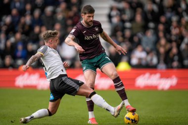 Swansea City 'den Cameron Burgess, 14 Şubat 2026' da İngiltere 'nin Derby şehrindeki Pride Park Stadyumu' nda oynanan Gökyüzü İddia Şampiyonası karşılaşmasında Derby County 'den Sammie Szmodics ile top mücadelesi veriyor.
