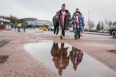 Stoke City taraftarları, 15 Şubat 2026 'da Birleşik Krallık' ın Trent kentindeki Bet365 Stadyumu 'nda oynanan 4. Raund Stoke City Fulham maçında yağmur bir süre durduktan sonra bir su birikintisinin yanından geçtiler.