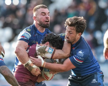Jacob Gagai of Huddersfield Giants is tackled by Mike McMeeken and Zac Woolford of Huddersfield Giants during the Betfred Super League Round 2 match Huddersfield Giants vs Wakefield Trinity at Accu Stadium, Huddersfield, United Kingdom on 22 February