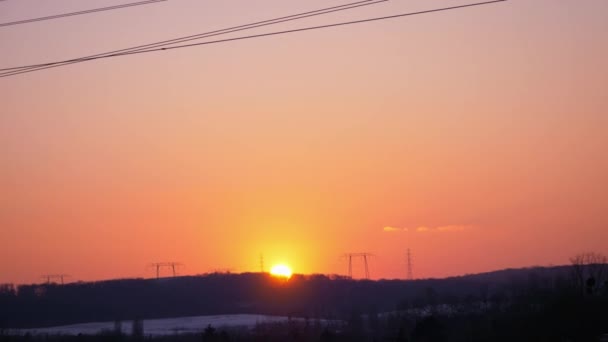 Statische Aufnahme Eines Farbenfrohen Sonnenuntergangs Über Der Von Hochspannungsleitungen Durchzogenen — Stockvideo