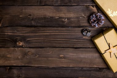 Noel kahverengi ahşap arka planda doğal dekorasyonlar ve hediyeler 