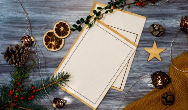 Beyaz ahşap zemin üzerine doğal süslerle süslenmiş Noel kartpostalı.