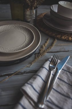 Tabak ve çatal bıçak, çiçek süslemeli ahşap bir masada.