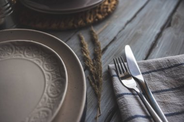 Tabak ve çatal bıçak, çiçek süslemeli ahşap bir masada.