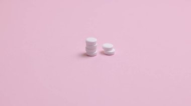 Pembe arka planda beyaz haplar