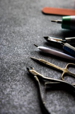 Gri arka planda manikür aletleri ve oje