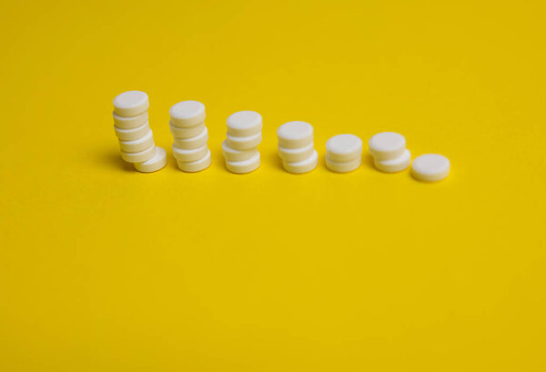 white pills on yellow background 