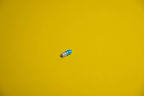 黄色背景的蓝色药丸 — 图库照片