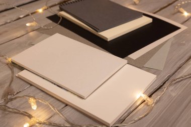 Boş boş kağıtlar ve ahşap arka planda ışıkları olan defterler. 