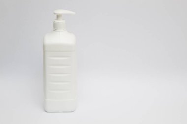 Beyaz arka planda bir antiseptik dezenfektan şişesi duruyor..