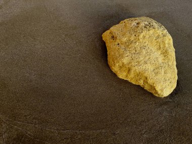 Gün batımından sonra kumsalda büyük bir kaya.