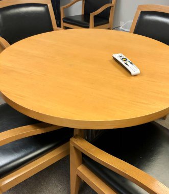 Yuvarlak ahşap masa, uzaktan kumandalı ve insan yok.