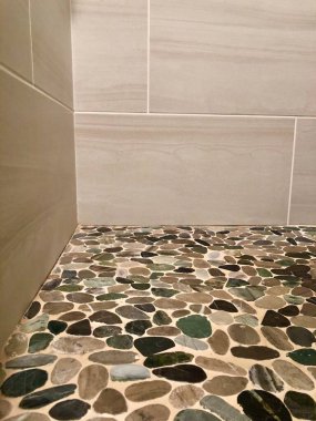 Düşük açılı ev içi duşa yakın fayans ve nehir taşlarıyla