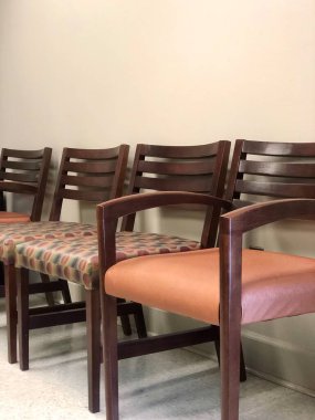 Profesyonel ofis bekleme odasında boş tahta sandalyeler ve çıplak duvarlar.