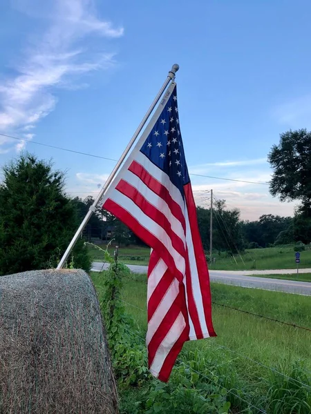 農村部の設定で干し草のベールにマウントされているアメリカ国旗 ストック写真