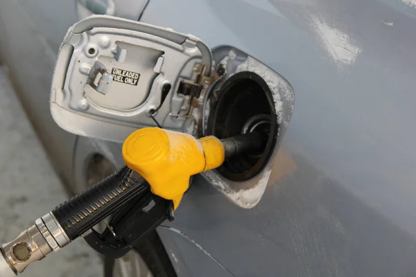 Pistola de reabastecimiento en el tanque de gasolina del coche. Repostando el coche en invierno. — Foto de Stock