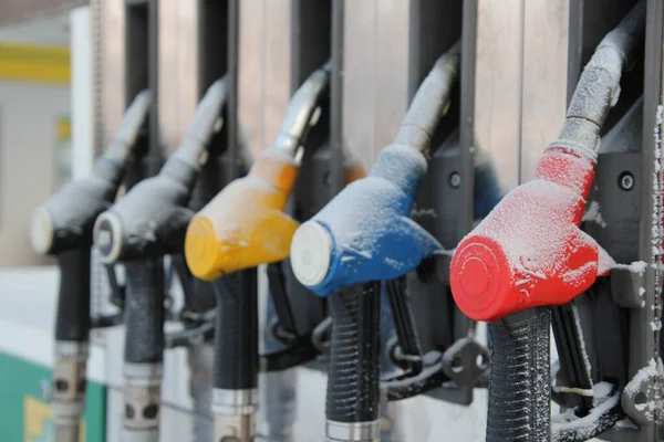 Refueling nozzles at a gas station covered with snow. The crisis.