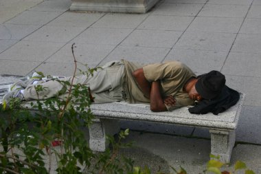 07.08.2007 Chicago, ABD. Siyah evsiz bir adam bankta uyuyor. 