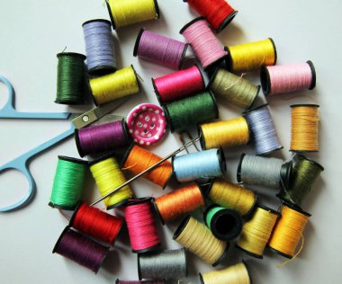 Aksesuar dikiyorum. Çok renkli iplikler, iğneler, makas, düğmeler.