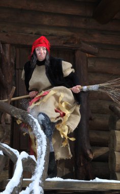 Baba Yaga kulübenin yanında süpürgeyle. Peri masalı için kostüm Morozko.