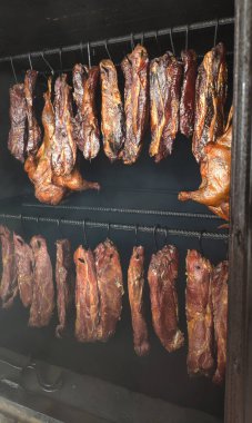 Et ve tavuk tütsüleme evinde tüttürülür. Duman fırını. Abhazya.