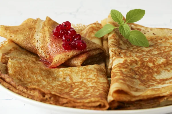 Pancakes with red currant jam and melissa leaves