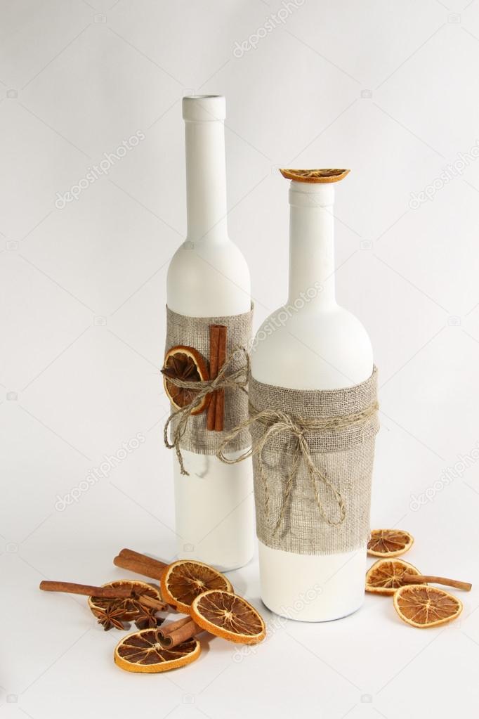 White bottles decorated with sackcloth and spices for mulled wine