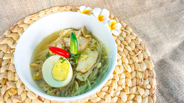 Ayam 'a ya da tavuk çorbasına yakın, Endonezya spesiyalitesi. Beyaz erişte, tavuk parçaları, fasulye filizi, özel otlar ve taze et suyundan oluşan bir dolgu.