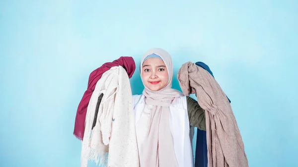 Фото Азиатской Мусульманки Пытающейся Выбрать Одежду Синем Фоне — стоковое фото