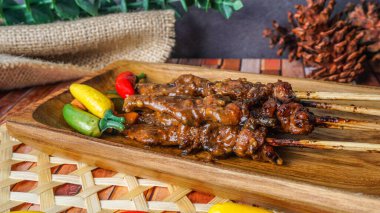 Seçici odak - Ahşap tabakta servis edilen ızgara tavuk satay