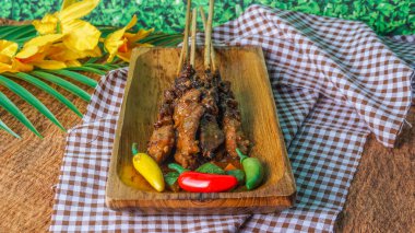 Ahşap tabakta taze tavuk satay, Malezya 'nın ünlü yemeği. Bir tabak baharatlı, şiş ve ızgara et, fıstık sosuyla servis edilir. seçici odak