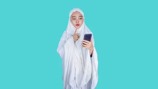 ラマダーン アイド フィトル アイド ムバラクのコンセプト イスラム教徒のヒジャーブスカーフを身に着けている深刻なアジアの女性ムケナ電話を保持することは インターネット読書メディア — ストック写真