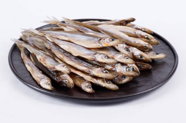 Yuvarlak tabakta baltik kurutulmuş eritilmiş balık, beyaz arka planda izole edilmiş bira atıştırmalığı.